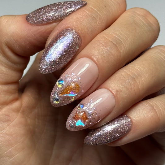 Photo du produit "Coachella" : des Press On Nails faits à la main en France, sur une base nude avec des paillettes et des strass de différents reflets de couleur, créant un effet festif et glamour.