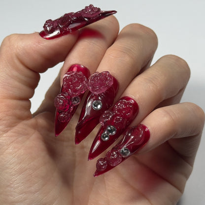 Adoptez le style avec "Red Roses" : des press-on nails rouges transparents intenses, décorés de roses 3D. Idéal pour des ongles glamour et faciles à appliquer. Commandez vos ongles press-on maintenant !